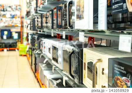 A Display of Various Microwaves Showcasing Different Designs, Sizes, and Features in a Well-Organized Retail Space for Kitchen Appliances A Display of Various Microwaves Showcasing Different Designs, Sizes, and Features in a Well-Organized Retail Space for Kitchen Appliances 141058929