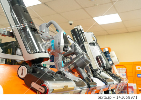 A Variety of Modern Vacuum Cleaners Displayed on Shelves in an Electronics Store, Showcasing the Latest Cleaning Technologies and Designs A Variety of Modern Vacuum Cleaners Displayed on Shelves in an Electronics Store, Showcasing the Latest Cleaning Technologies and Designs 141058971