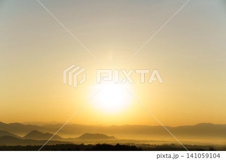 Golden sunrise over the layered mountain during foggy day. 141059104