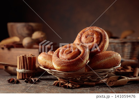 Freshly baked cinnamon doughnuts on a brown background. 141059476
