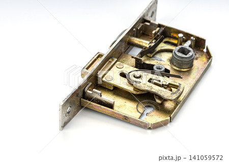 Close up of disassembled brass mortise door lock mechanism revealing intricate internal components including springs latches bolt tumblers and cylinder housing on white background Close up of disassembled brass mortise door lock mechanism revealing intricate internal components including springs latches bolt tumblers and cylinder housing on white background 141059572