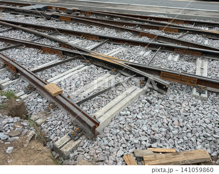 Railway switch with intersecting tracks, ballast, concrete sleepers and steel rails on modern rail infrastructure. Transportation, logistics, railway engineering, infrastructure, mobility, freight Railway switch with intersecting tracks, ballast, concrete sleepers and steel rails on modern rail infrastructure. Transportation, logistics, railway engineering, infrastructure, mobility, freight 141059860