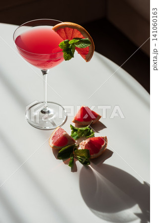Pink grapefruit cocktail with mint and citrus garnish Pink grapefruit cocktail with mint and citrus garnish 141060163