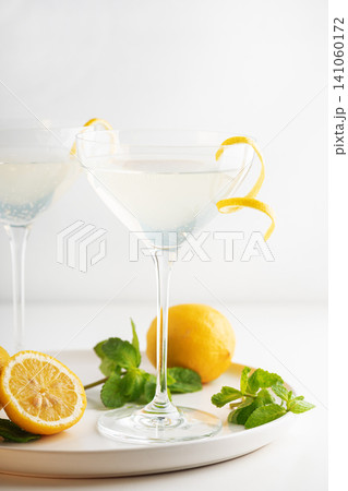 Refreshing lemon cocktail in martini glass with mint garnish Refreshing lemon cocktail in martini glass with mint garnish 141060172