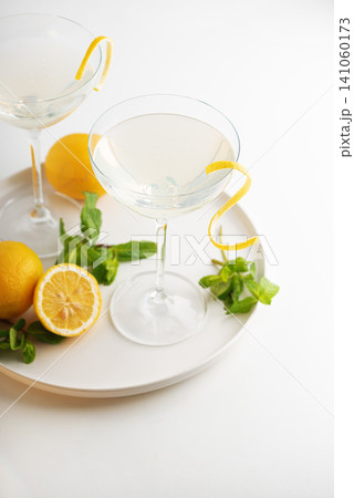 Refreshing lemon cocktails with mint sprigs on a white tray 141060173