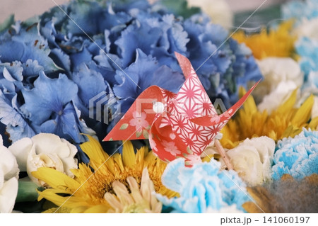青い紫陽花と夏の花々に囲まれた赤い和柄の風車 青い紫陽花と夏の花々に囲まれた赤い和柄の風車 141060197