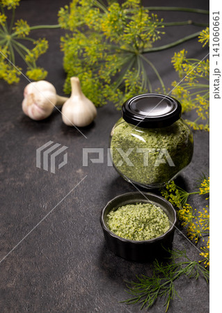 Dill herb salt in jars with garlic 141060661