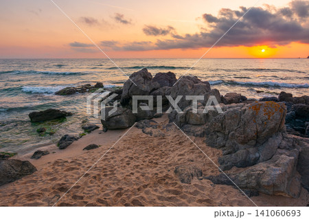 huge stones on a sandy beach at sunrise. wonderful summer vacation season at the black sea. calm waves washing the sand shore. nature background with cloudy sky. bulgaria travel photo huge stones on a sandy beach at sunrise. wonderful summer vacation season at the black sea. calm waves washing the sand shore. nature background with cloudy sky. bulgaria travel photo 141060693