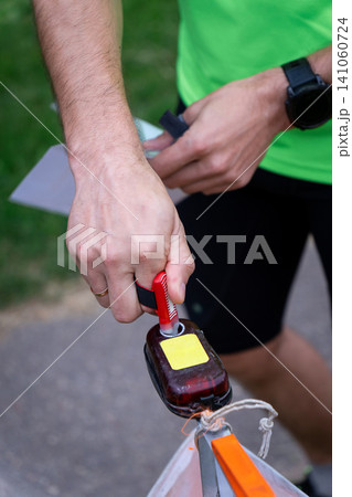 an orienteering athlete using an electronic timing punch 141060724