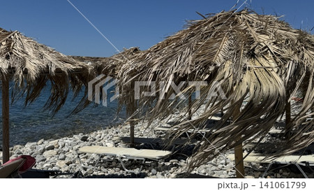 Beach Sun Loungers Under Straw Umbrellas by the Sea 141061799
