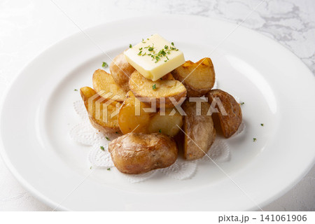バターがのったロースト ポテトをメインに盛り付けた高級ステーキ料理 バターがのったロースト ポテトをメインに盛り付けた高級ステーキ料理 141061906