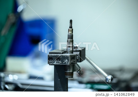 Dirty used common rail diesel fuel injector with carbon deposit fixed in metal clamp holder for repair in workshop Dirty used common rail diesel fuel injector with carbon deposit fixed in metal clamp holder for repair in workshop 141062849