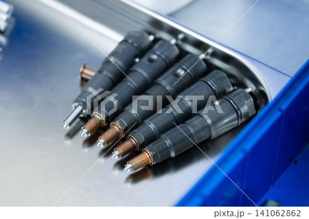 Set of repaired clean common rail diesel fuel injectors with new nozzles on metal tray in automotive workshop Set of repaired clean common rail diesel fuel injectors with new nozzles on metal tray in automotive workshop 141062862