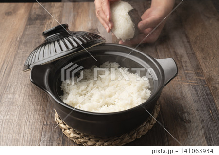 土鍋で炊いたご飯でおにぎりを握る 土鍋で炊いたご飯でおにぎりを握る 141063934