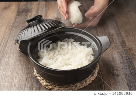 土鍋で炊いたご飯でおにぎりを握る 土鍋で炊いたご飯でおにぎりを握る 141063936
