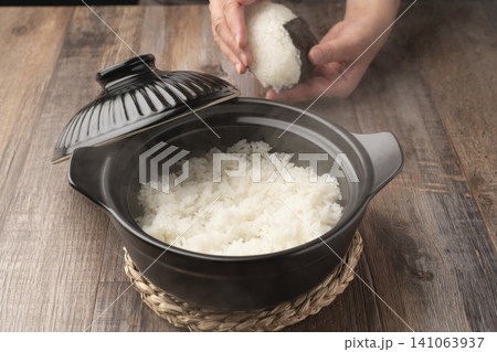 土鍋で炊いたご飯でおにぎりを握る 土鍋で炊いたご飯でおにぎりを握る 141063937