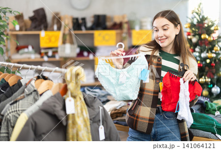 Positive young woman choosing panties in clothing store 141064121