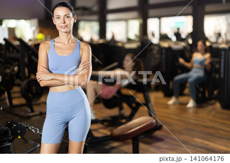 Positive young girl standing in well-equipped gym 141064176