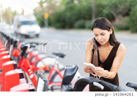 Girl tourist rents moped. Eco-friendly transport, city life. Girl tourist rents moped. Eco-friendly transport, city life. 141064261