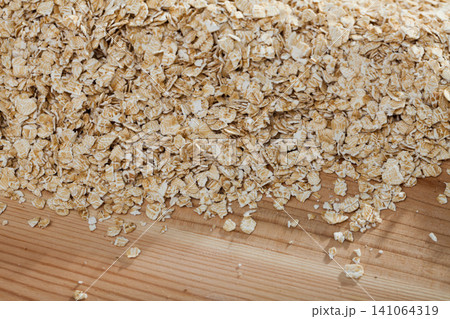 Oat-flakes on wooden surface 141064319