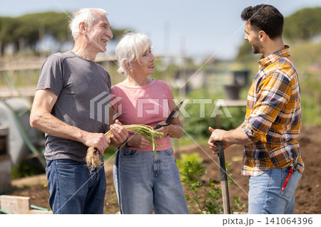 Farmers friendly talking outdoor on background with farm Farmers friendly talking outdoor on background with farm 141064396