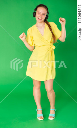 Teenage girl with a smile on her face enjoys high-quality sound and music in headphones Teenage girl with a smile on her face enjoys high-quality sound and music in headphones 141064841