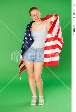 Teenage girl holding USA flag in front of green screen 141065080