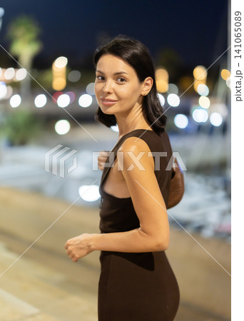 Woman walking along coastal promenade at night in Barcelona Woman walking along coastal promenade at night in Barcelona 141065089