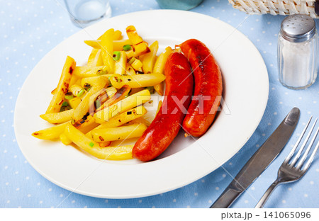 Close up of tasty fried pork sausages with french fries Close up of tasty fried pork sausages with french fries 141065096