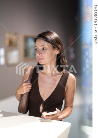 Woman looking at historical exhibits in museum Woman looking at historical exhibits in museum 141065141
