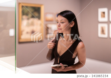 Woman looking at historical exhibits in museum 141065154