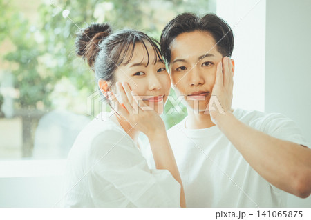 顔に手を当て穏やかにカメラを見つめるカップルのシェア美容ペアビューティーイメージポートレート 顔に手を当て穏やかにカメラを見つめるカップルのシェア美容ペアビューティーイメージポートレート 141065875
