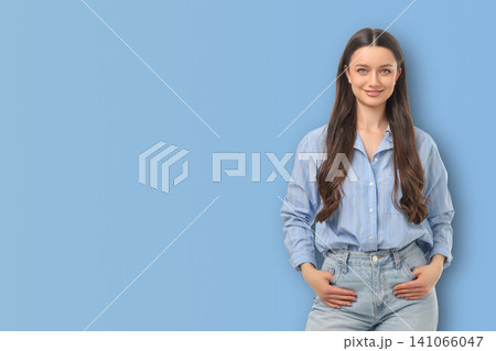 Model stands in blue space with hands in pockets Model stands in blue space with hands in pockets 141066047