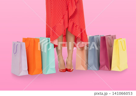 Woman with red dress holds shopping bags on pink background Woman with red dress holds shopping bags on pink background 141066053
