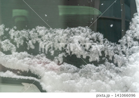大雪でリアガラスに雪が付着した車のクローズアップ 大雪でリアガラスに雪が付着した車のクローズアップ 141066096