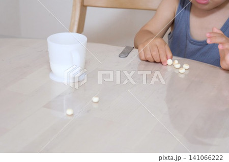 おやつのボーロを食べる子供の手元と牛乳 おやつのボーロを食べる子供の手元と牛乳 141066222