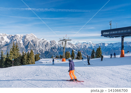 Skiers on a sunny slope near the ski lift station in Saalbach, Austria during winter season Skiers on a sunny slope near the ski lift station in Saalbach, Austria during winter season 141066700