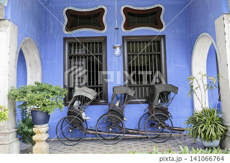 Colorful house with blue walls and black window bars 141066764