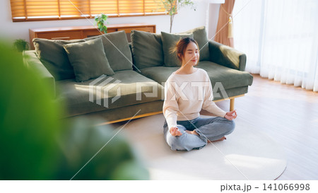 Happy young Asian woman practicing yoga and meditation at home 141066998