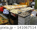 Fresh vegetables and seafood on market stall in outdoor setting 141067514