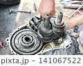 Mechanic repairing gear system on a motorcycle engine 141067522
