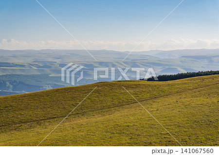 Layers of green mountains and hills in the haze during sunset. Panoramic View of Green hills and Meadow. Layers of green mountains and hills in the haze during sunset. Panoramic View of Green hills and Meadow. 141067560