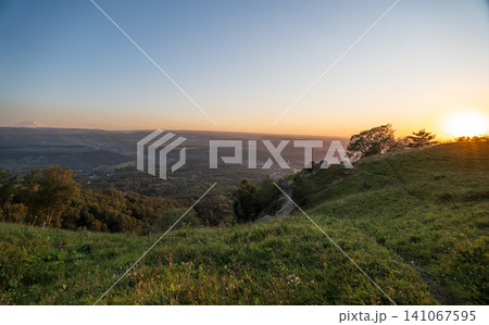 View of the mountains and Kislovodsk from the observation decks of the Kislovodsk Park. Evening sunset over the mountains of Kislovodsk. View of the mountains and Kislovodsk from the observation decks of the Kislovodsk Park. Evening sunset over the mountains of Kislovodsk. 141067595