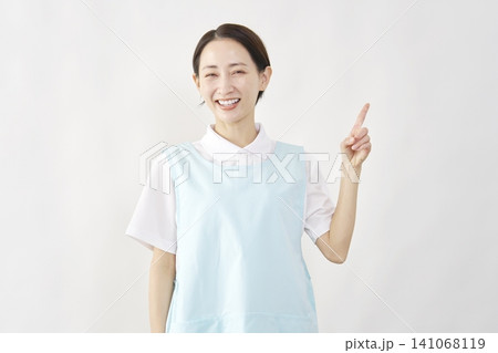 右側を指差す介護士女性 白背景 右側を指差す介護士女性 白背景 141068119