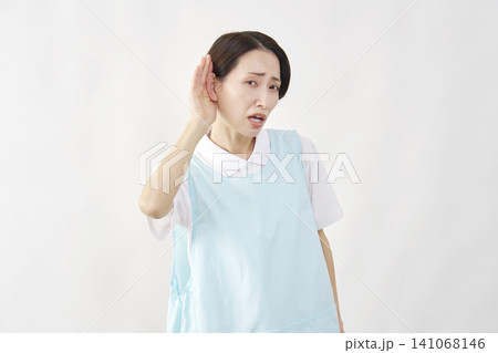 耳に手を当てる介護士女性 白背景 耳に手を当てる介護士女性 白背景 141068146
