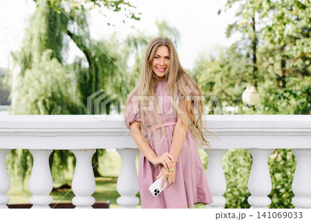 Beautiful Woman In Pink Summer Dress Holding Smartphone Beautiful Woman In Pink Summer Dress Holding Smartphone 141069033