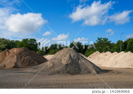 Construction Aggregate Stockpiles with Sand and Gravel at Building Materials Storage Yard Under Blue Sky Construction Aggregate Stockpiles with Sand and Gravel at Building Materials Storage Yard Under Blue Sky 141069068