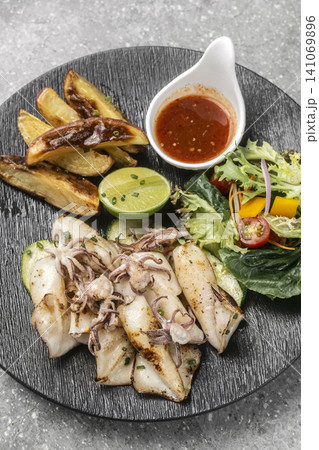 mediterranean grilled fresh squid meal on restaurant table 141069896