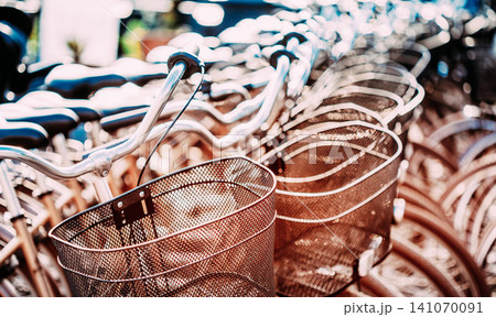 Close Up Of Basket Of Bicycle On Parking. Sunlight Sunshine Through Bikes. Bokeh Background. 141070091