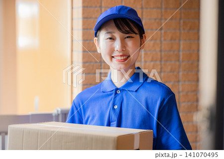 荷物を届ける宅急便の女性ドライバー 141070495
